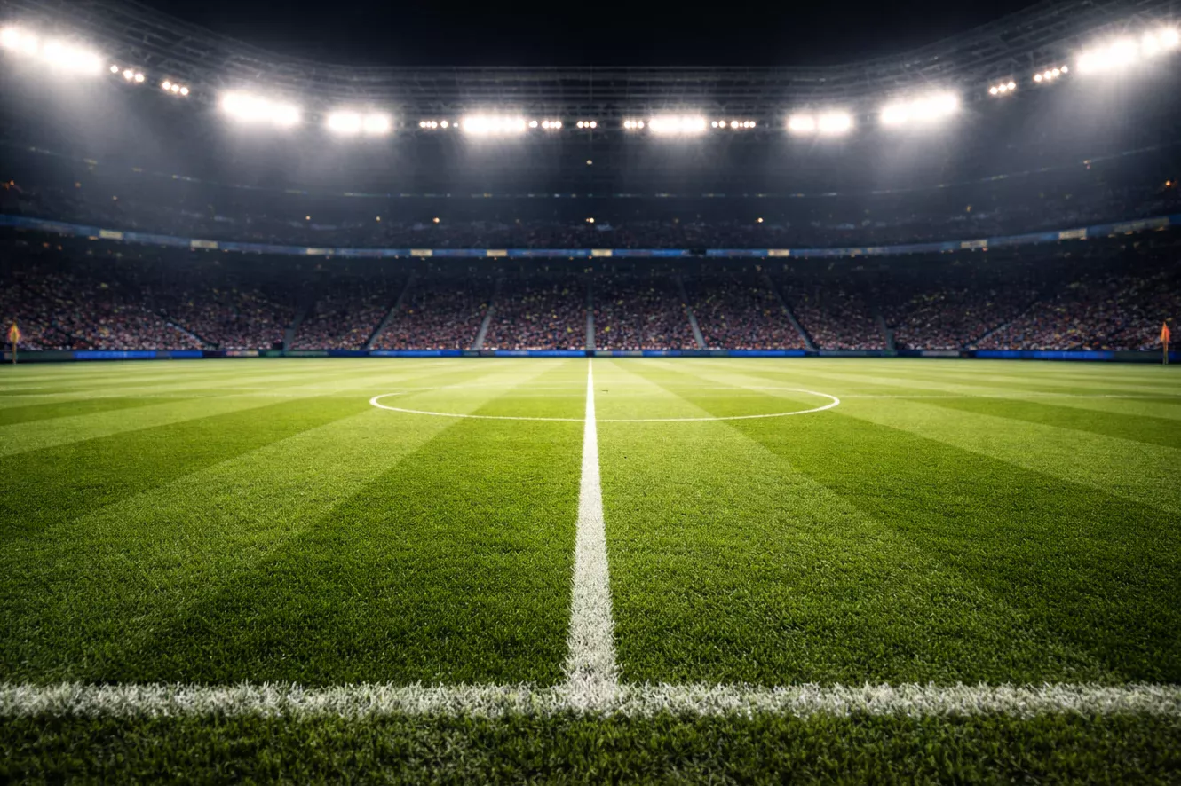 Campo de fútbol con el césped impecable antes de un partido de Champions League bajo los focos