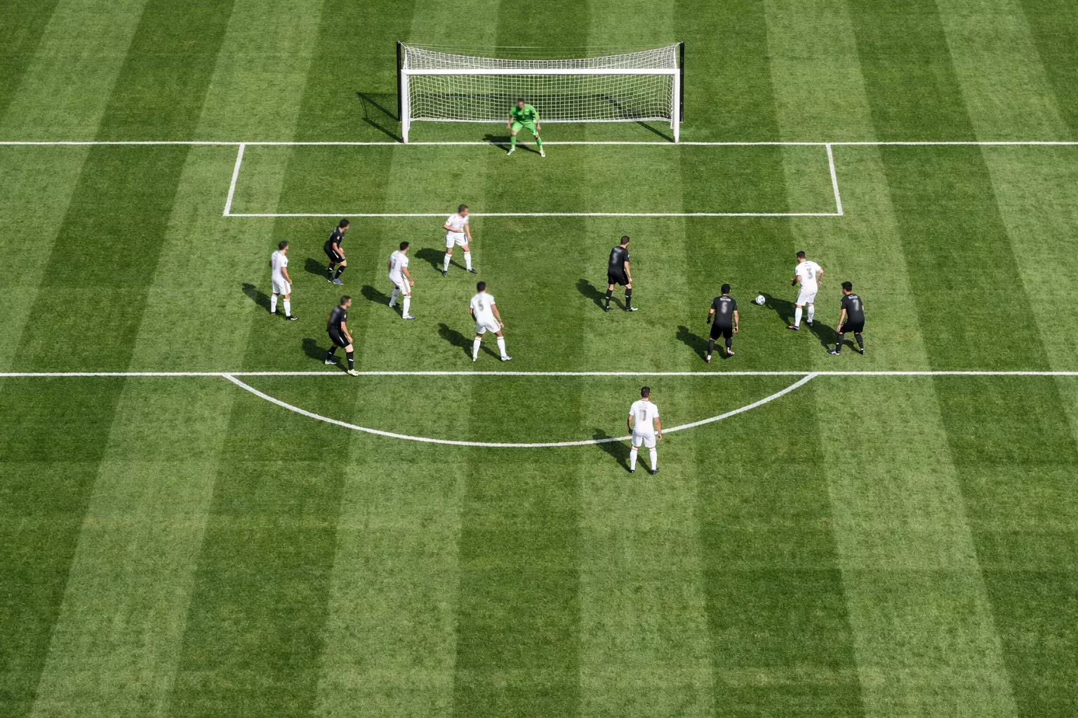 Vista aérea de un campo de fútbol con jugadores posicionados durante un ataque al área